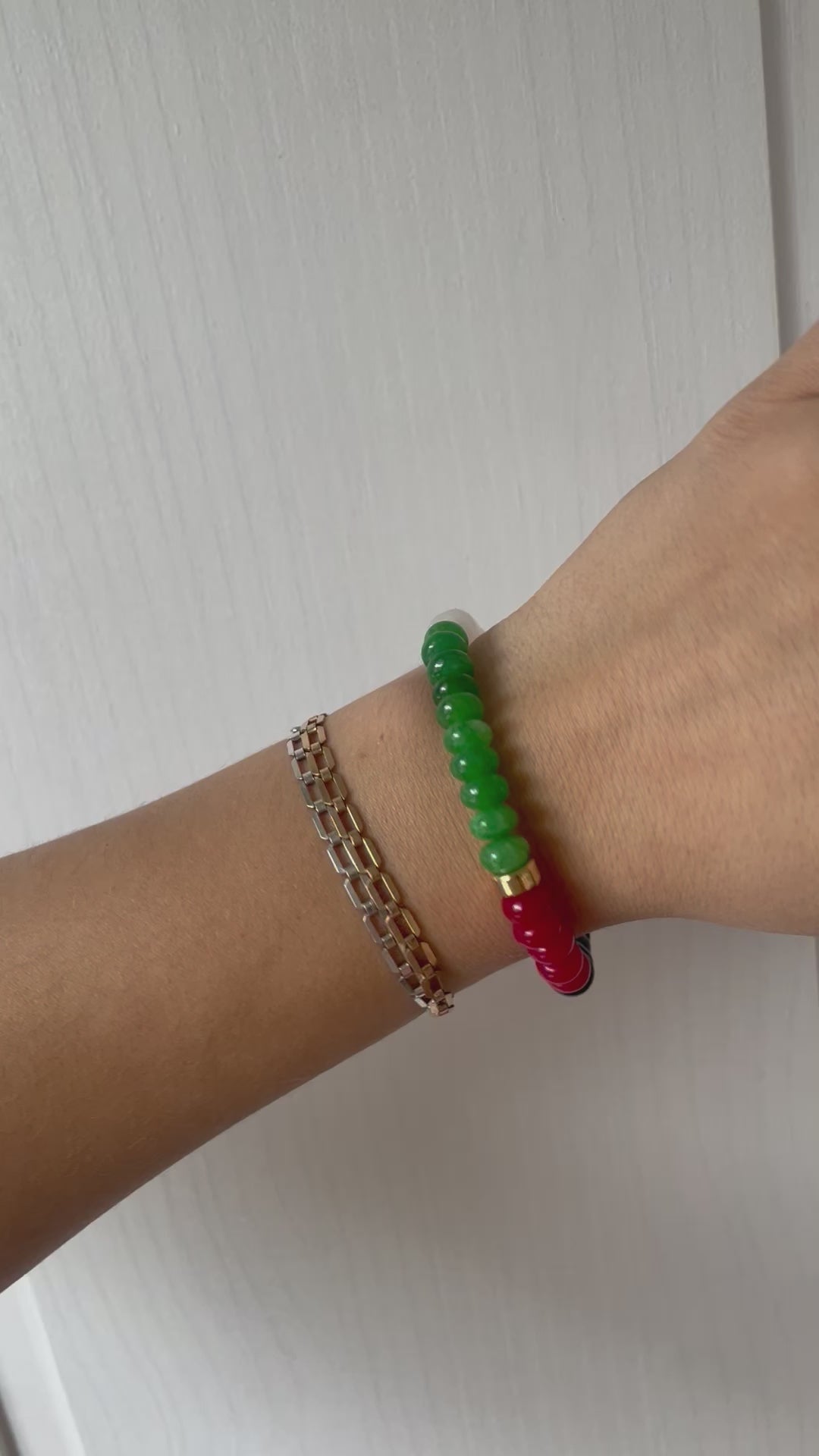 video shows a beaded bracelet with the colors of the Palestinian Flag and a gold accent bead.